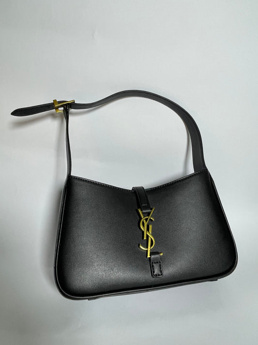 Black handbag with a gold logo on a light gray background